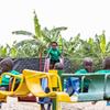 Watoto waliovaa sare za kijani hucheza kwenye uwanja wa michezo katika kituo cha maendeleo ya watoto wadogo kaskazini mwa Rwanda.