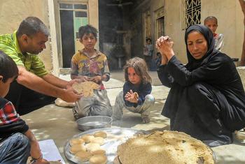 عائلة تأكل الخبز المصنوع على  فرن حطب من الطحين المقدم من برنامج الأمم المتحدة الإنمائي في سوريا.