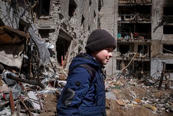 A ten-year-old boy walks in the courtyard in front of his family’s apartment in central Chernihiv, Ukraine, which was destroyed in an air strike.