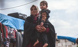 A widow holds her grandson in a displaced persons camp in northern Idlib Governorate, Syria.