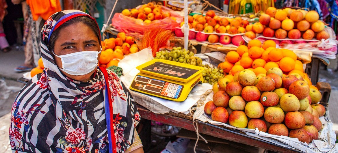 孟加拉国首都达卡的一位妇女正在集市上摆摊售卖水果。