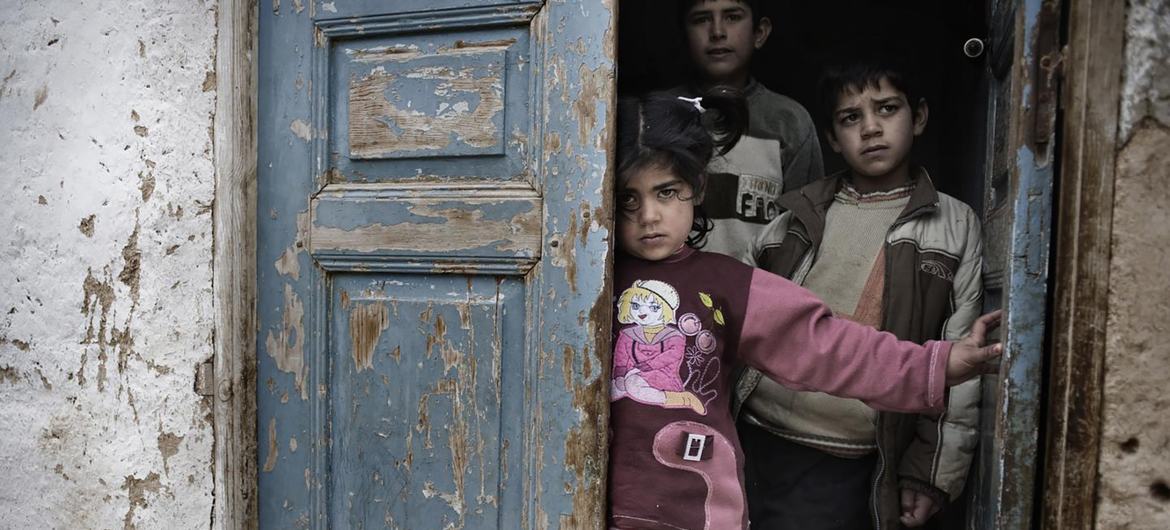 Des enfants sur le pas d'une porte dans un quartier paupérisé de Beyrouth, au Liban.