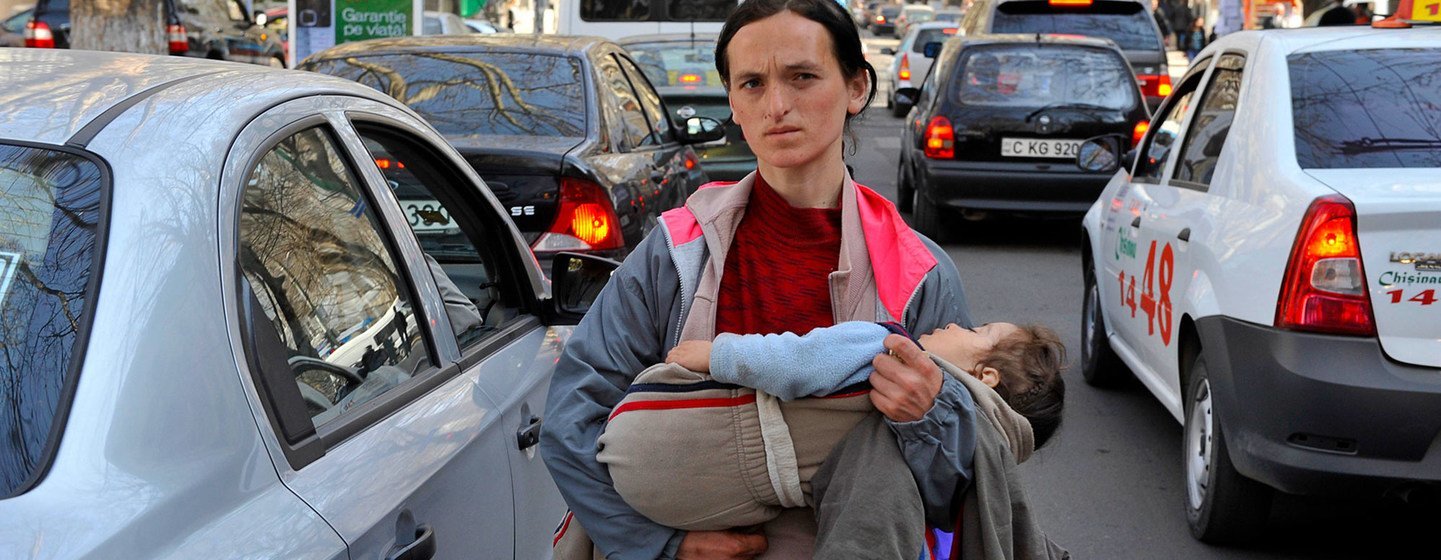 Une femme porte son enfant tout en mendiant dans les rues de Chisinau en Moldavie.