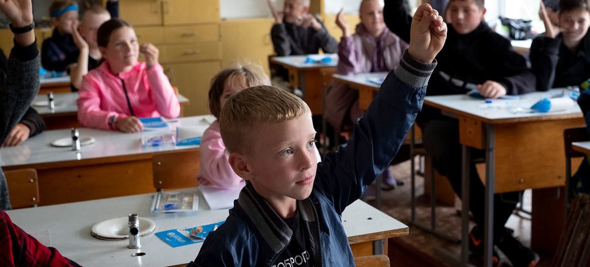 Unos niños asisten a clase en una escuela de Olyzarivka (Ucrania). La aldea estuvo en la línea del frente  de batalla durante semanas y resultó gravemente dañada.