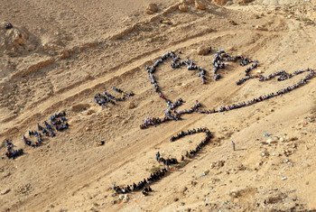 المئات من الطلاب من مدرسة تابعة للأمم المتحدة قرب أريحا يشكلون صورة جوية لحمامة السلام لبيكاسو، بالاشتراك مع الفنان الشهير جون كويجلي. (تشرين الثاني/نوفمبر 2011)