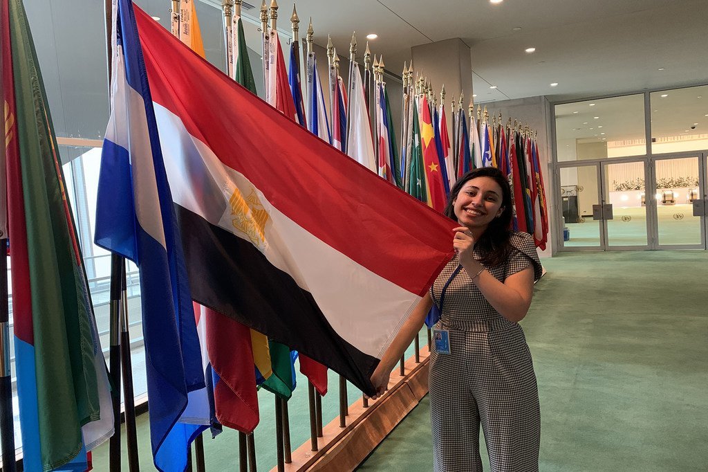 من مصر، ليلى شوما متدربة في القسم العربي بأخبار الأمم المتحدة، تتصور مع علم بلادها أمام قاعة الجمعية العامة للأمم المتحدة في نيويورك.