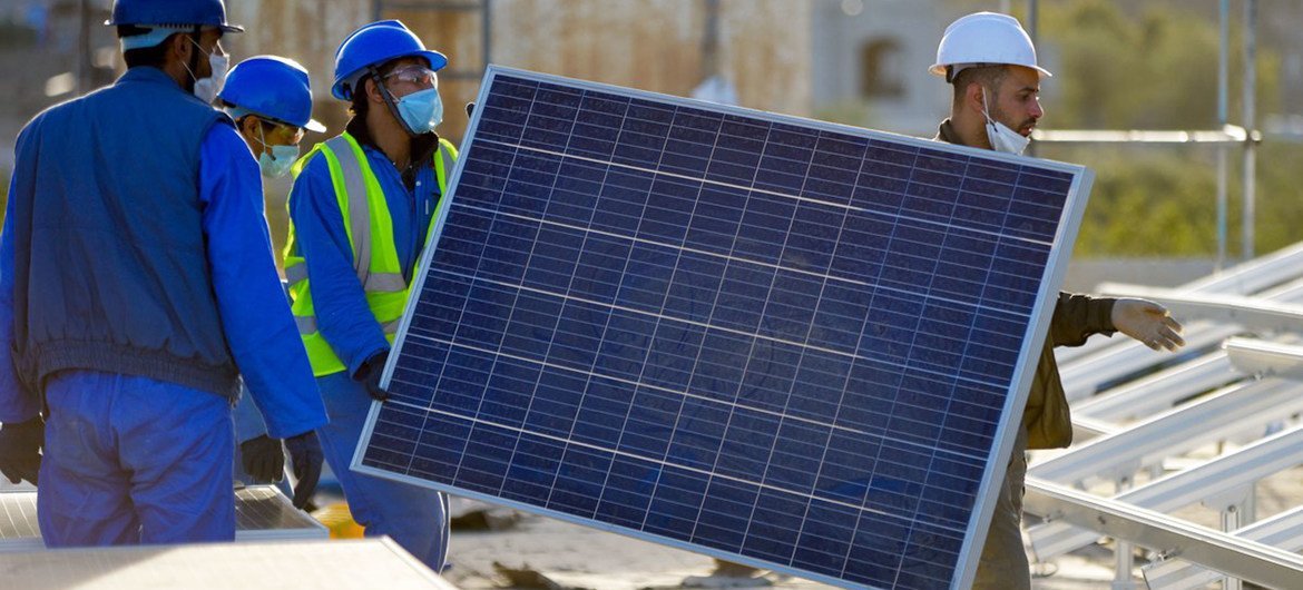 Des hommes installent des panneaux solaires pour un hôpital au Yémen.