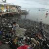 رجل يجمع لوحا معدنيا من أحد الشواطئ التي دمرها إعصار راي في الفلبين.