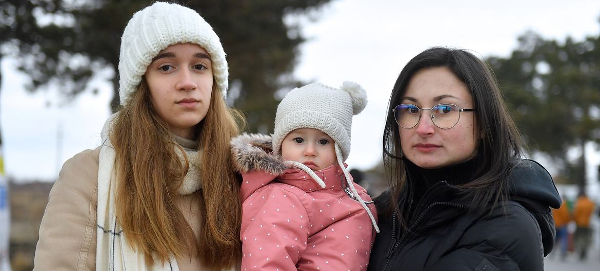 Tania (right), stands with her sister and young daughter at the Siret border between Romania and Ukraine.