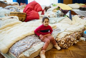 فتاة تبلغ من العمر سبع سنوات تجلس على سرير في ملجأ من الغارات الجوية في لفيف، غرب أوكرانيا.
