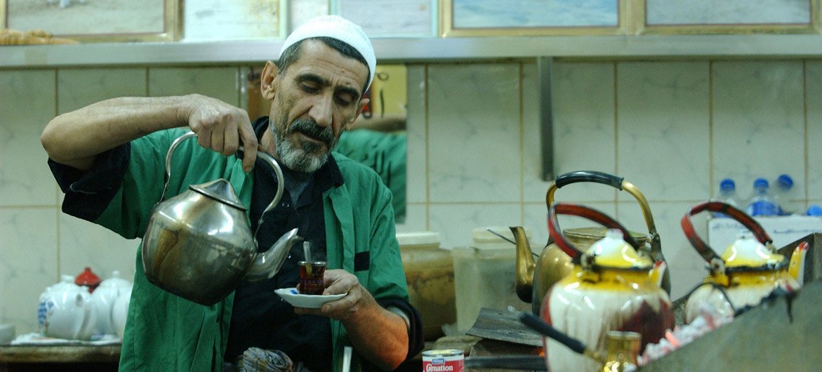 एक व्यक्ति कुवैत की एक कॉफी शॉप में चाय तैयार कर रहा है.