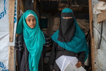 Rania and her eldest daughter, Amani, stand in the entrance to their home in a camp for internally displaced people in Lahj, Yemen.