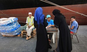 Un employé de l'UNICEF écoute deux femmes qui demandent de l'eau dans le port de Tripoli, la capitale de la Libye. (archives)