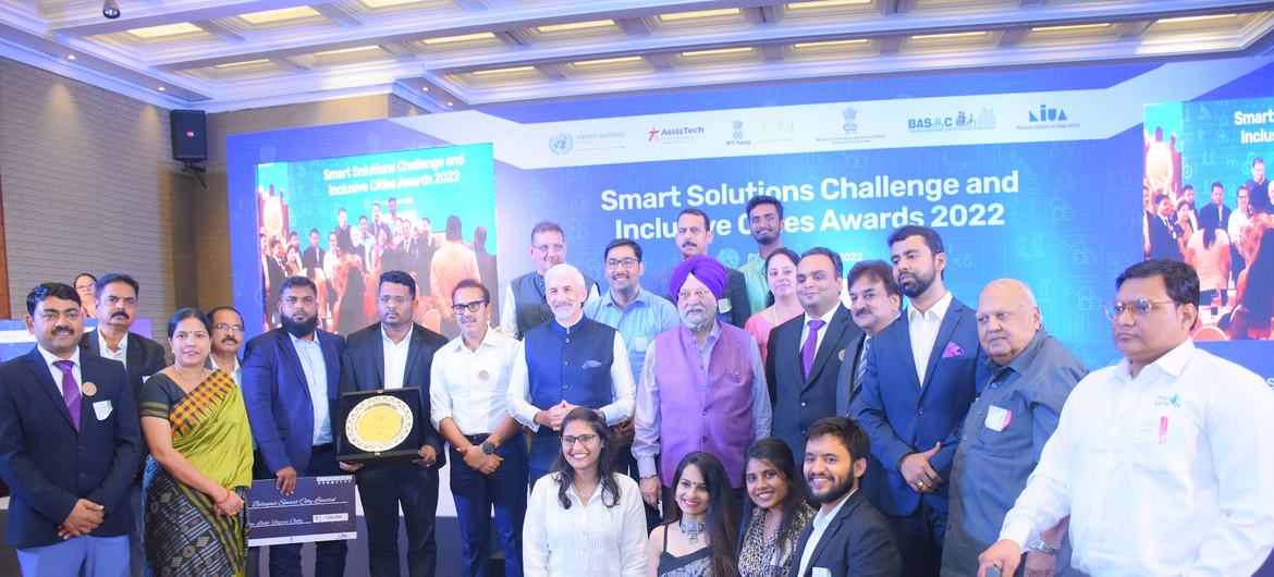इनक्लूसिव सिटीज अवार्ड्स 2022 में पुरस्कार प्राप्त करने के बाद मंच पर फोटो खिंचवाते हुए लोगों का एक समूह।