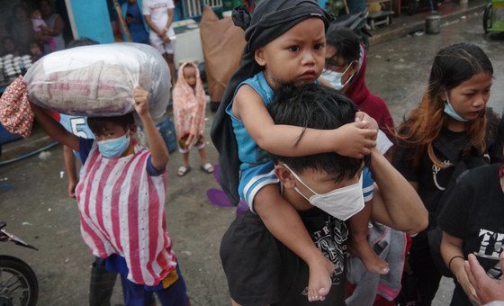 Pessoas evacuadas chegando a centro de acolhimento em Manila