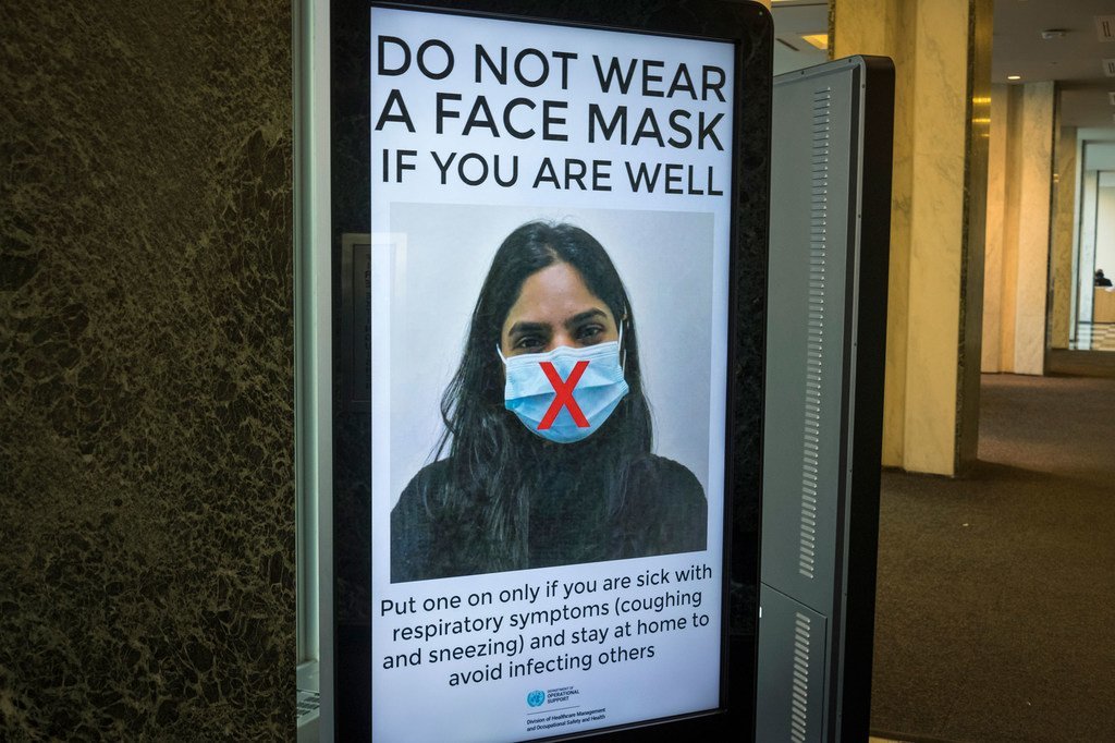 在联合国纽约总部，工作人员得到有关正确使用口罩的指导。