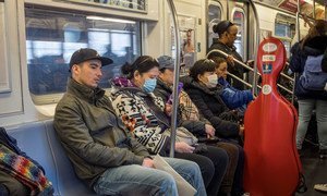 纽约州报告了首例2019冠状病毒病例后，乘客戴着口罩乘坐地铁。