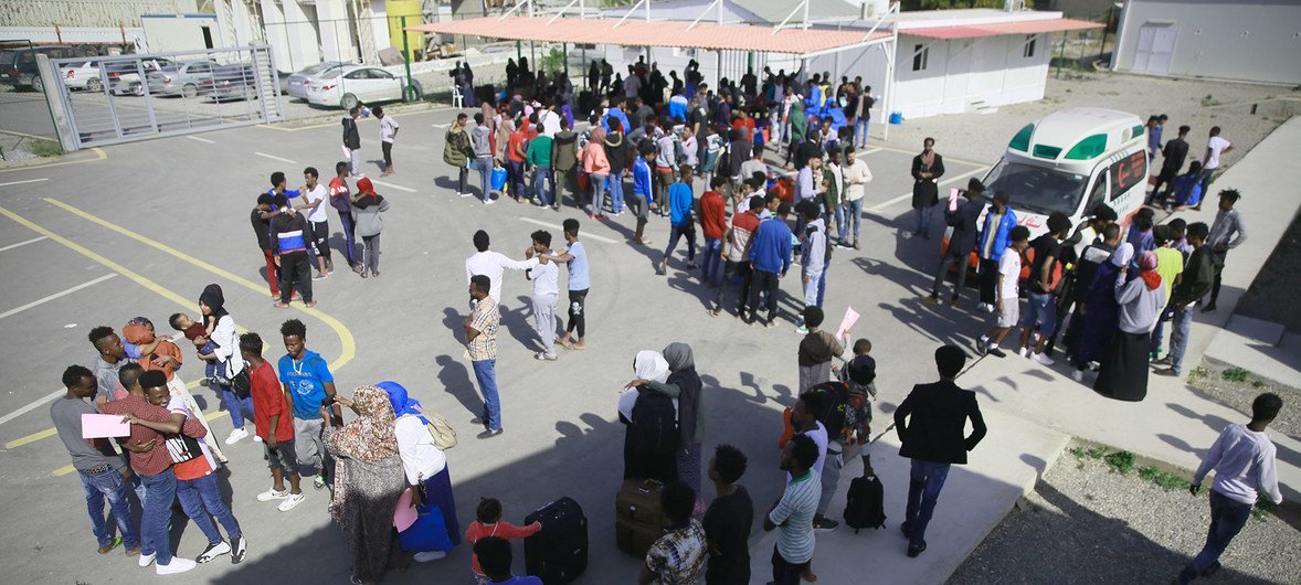 اللاجئون من الصومال وسوريا وإريتريا الذين أُفرج عنهم من مراكز الاحتجاز في ليبيا، مع موظفي مفوضية اللاجئين في مرفق التجمع والمغادرة التابع للمفوضية في طرابلس، ليبيا، خلال القيام بإجراءات الإجلاء. 