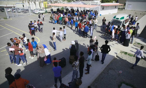 Refugiados da Somália, Síria e Eritreia, que foram libertados dos centros de detenção na Líbia, com funcionários do Centro de Recolhimento e Partida do Acnur em Trípoli, na Líbia.