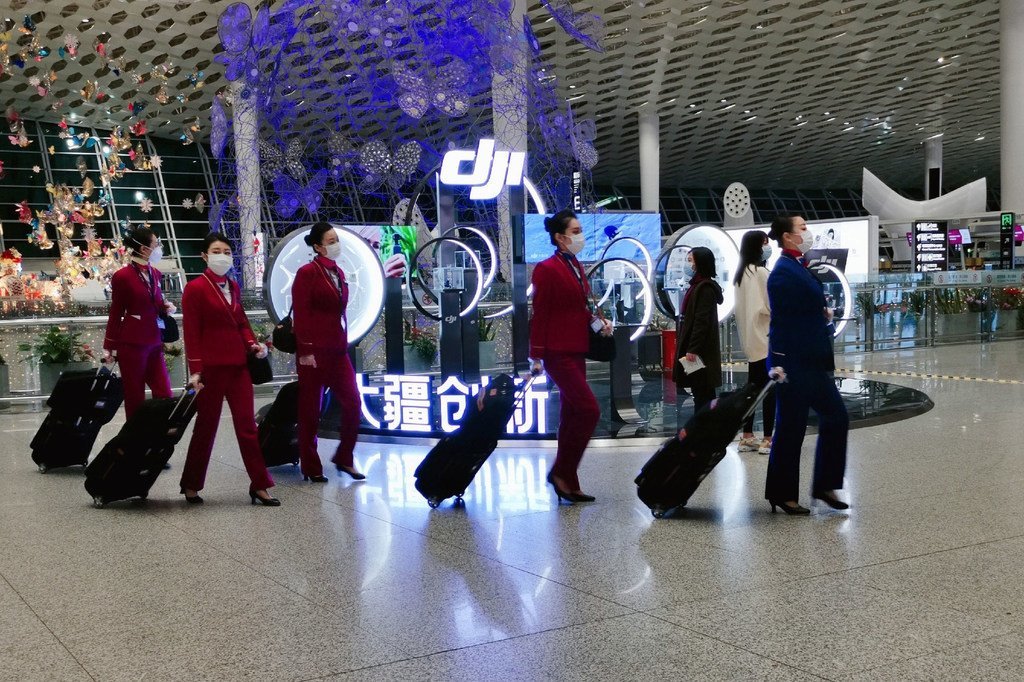 佩戴口罩的乘务员行走在中国深圳宝安国际机场。