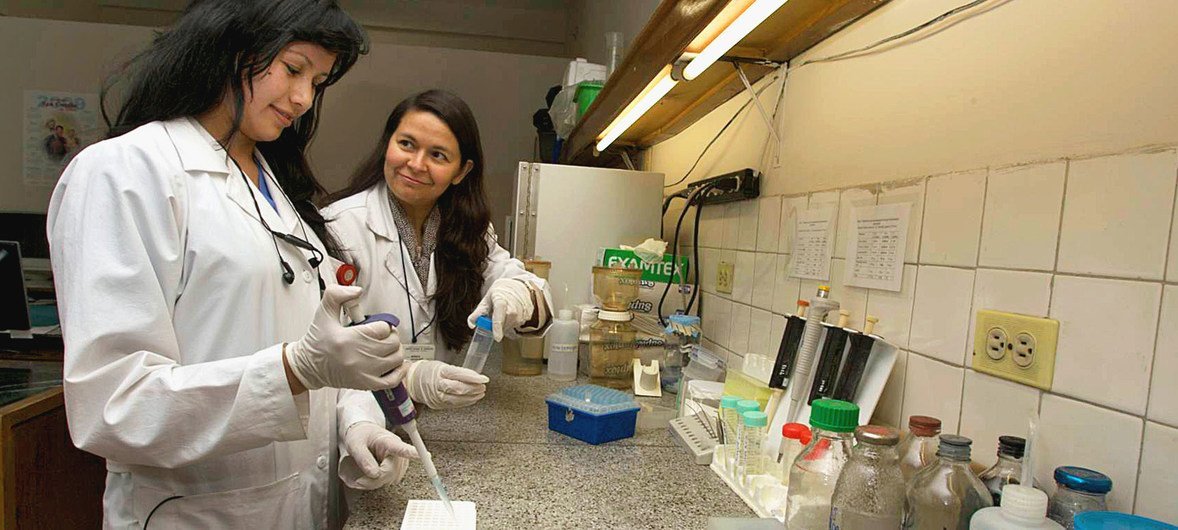 在哥伦比亚国家癌症研究所，一名研究助理（左）正在接受一位生物学家的培训。