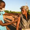 मलावी में एक महिला को कोविड-19 से बचाव के लिये टीका लगाया जा रहा है.