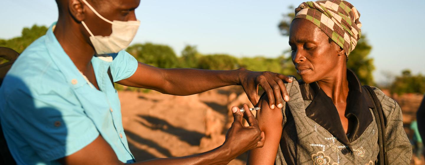 Un agent de santé administre un vaccin COVID-19 à une femme, au Malawi.