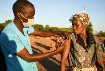 मलावी में एक महिला को कोविड-19 से बचाव के लिये टीका लगाया जा रहा है.