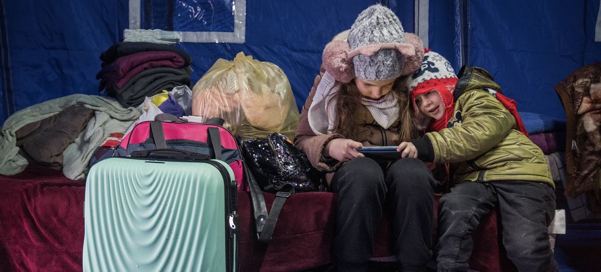 A nine-year-old girl and her three-year-old brother arrive at a temporary shelter in Romania after fleeing the conflict in Ukraine with their mother.