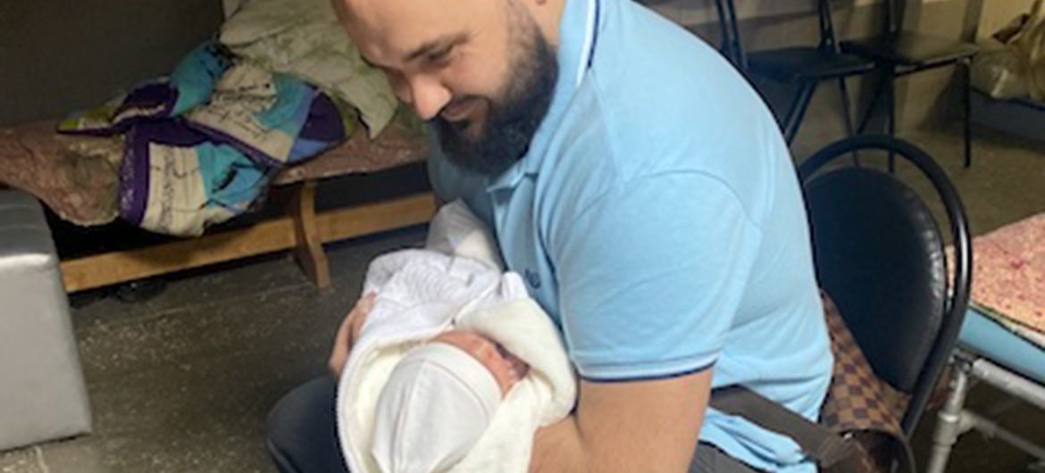 Le mari de Mariia Shostak, Yurii, tient dans ses bras sont fils à l'hôpital, à Kyïv.