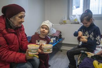 Senhora e os netos após cruzarem a fronteira com a Romênia. Os pais das crianças ficaram na Ucrânia. 