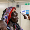 Mulher no Sudão do Sul tem sua temperatura verificada antes de regressar para casa, em Bentiu