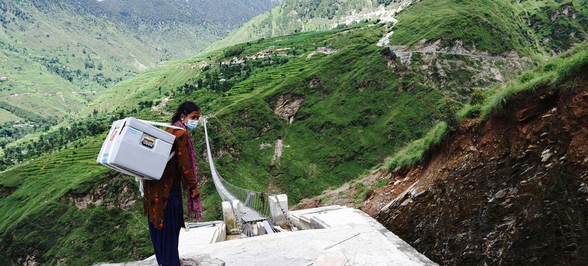 Una trabajadora de salud lleva vacunas COVID-19 donadas por COVAX a un centro sanitario en Nepal.