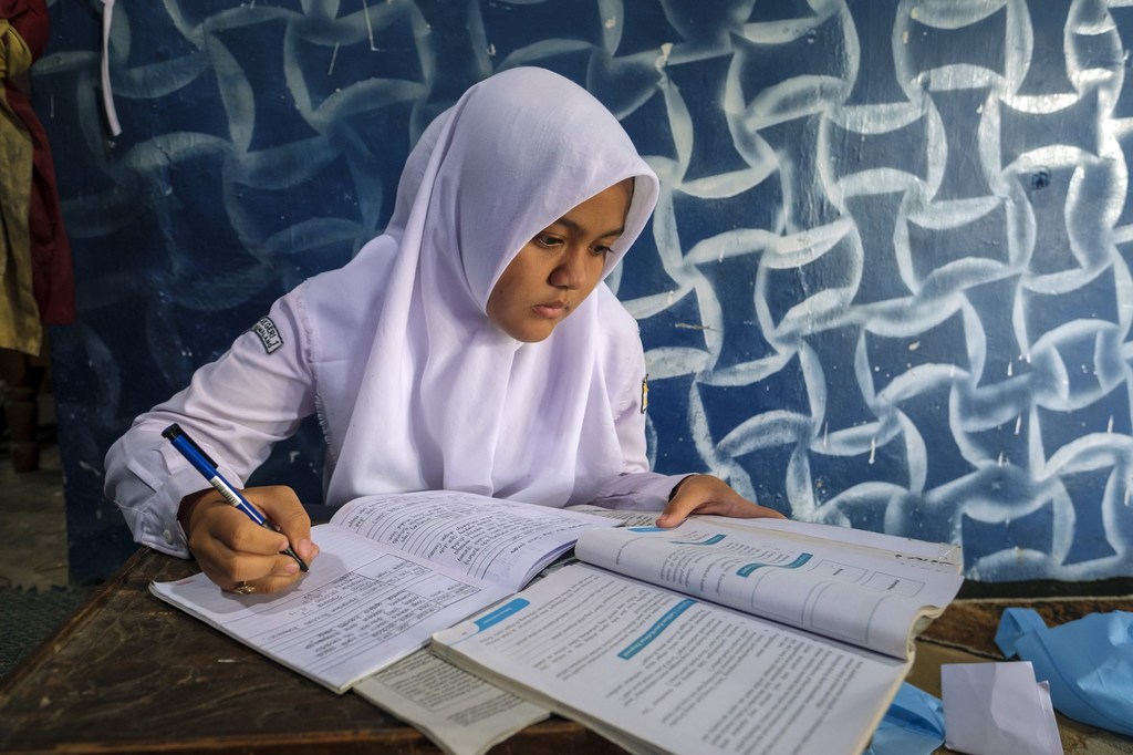 Keysha, 14 ans, fait ses devoirs chez elle à Sragen, en Indonésie.