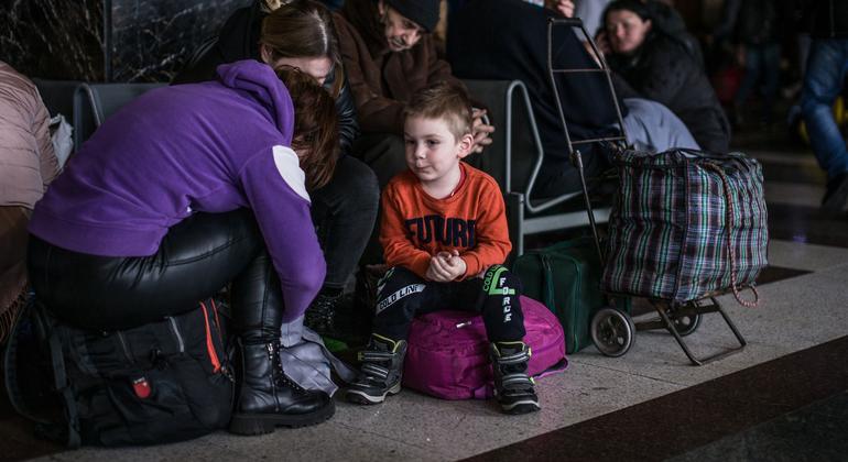 Ucranianos esperam trens de evacuação em uma estação ferroviária em Kyiv.