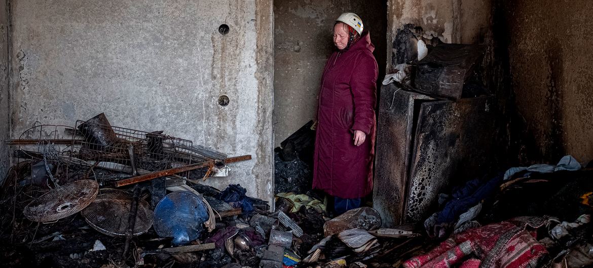 امرأة تبلغ من العمر 70 عامًا تقف عند مدخل شقتها التي تعرضت للقصف والحرق في وسط تشيرنيهيف ، أوكرانيا.