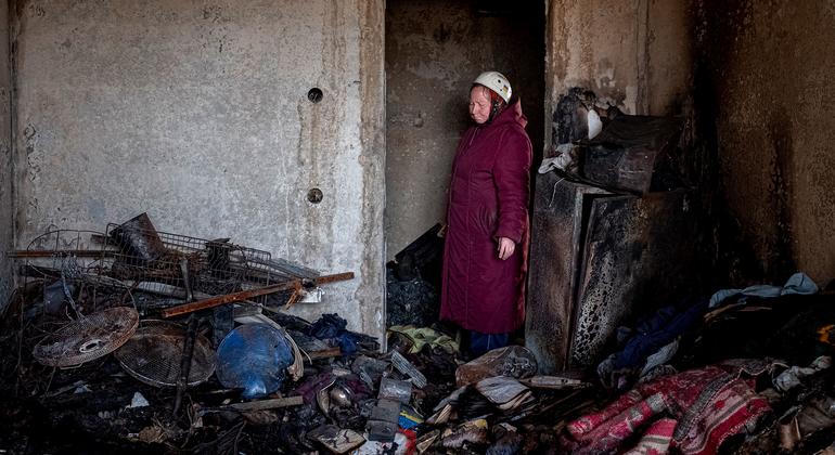 A 70-year-old woman stands in the doorway of her bombed and burnt out apartment in central Chernihiv, Ukraine.