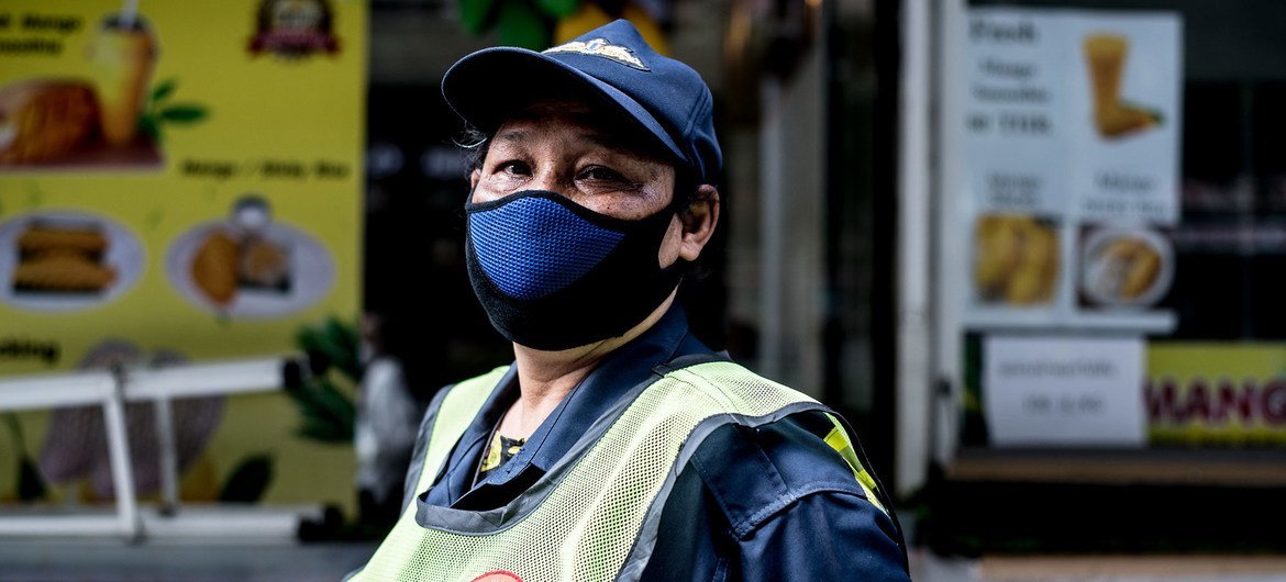 Una trabajadora de limpieza utiliza una mascarilla durante la pandemia de COVID-19 en Tailandia.
