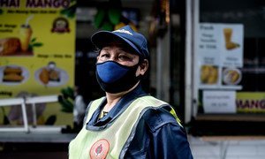 Una trabajadora de limpieza utiliza una mascarilla durante la pandemia de COVID-19 en Tailandia.