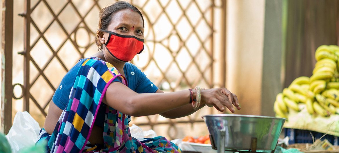 امرأة ترتدي قناع الوجه أثناء العمل في غوجارات بالهند.