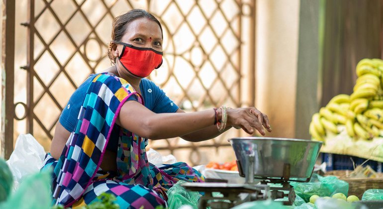 Una mujer utiliza mascarilla mientras trabaja en Gujarat, India, en medio de la pandemia de covid-19