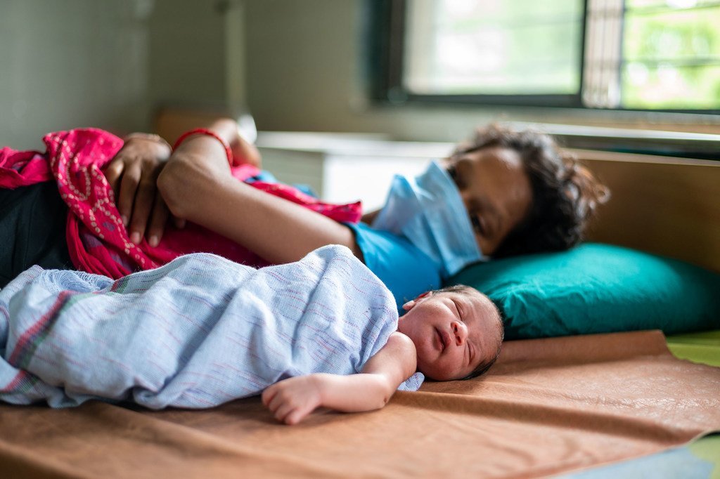 Une mère sur un lit d'hôpital avec son bébé né pendant la pandémie de Covid-19 dans le Gujarat, en Inde.