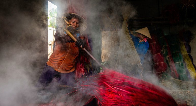 Two farmers in Viet Nam dye fibres they have cultivated.