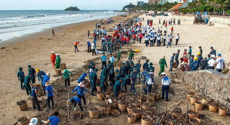 A seaside community in a tourist area in Viet Nam gets together to collect rubbish from the sea.