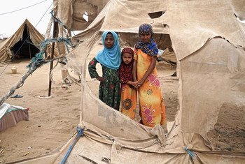 Displaced children stand in the shredded remains of tents in Abs settlement, Yemen, for internally displaced persons. Located just 40 km from the frontlines, the settlement is regularly damaged by passing sandstorms.