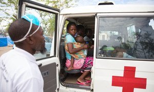 A mother and her baby sit in an ambulance at an accommodation centre in Beira, Mozambique, where her 2-year-old daughter is being treated for malaria.