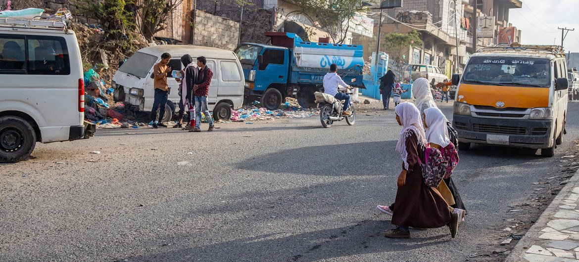 也门塔伊兹，年轻女孩在上学的路上穿过马路。