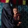 Une mère amène son bébé de 7 mois souffrant de malnutrition sévère à une équipe mobile de santé et de nutrition dans un village du district de Maiwand, dans la province de Kandahar, en Afghanistan.