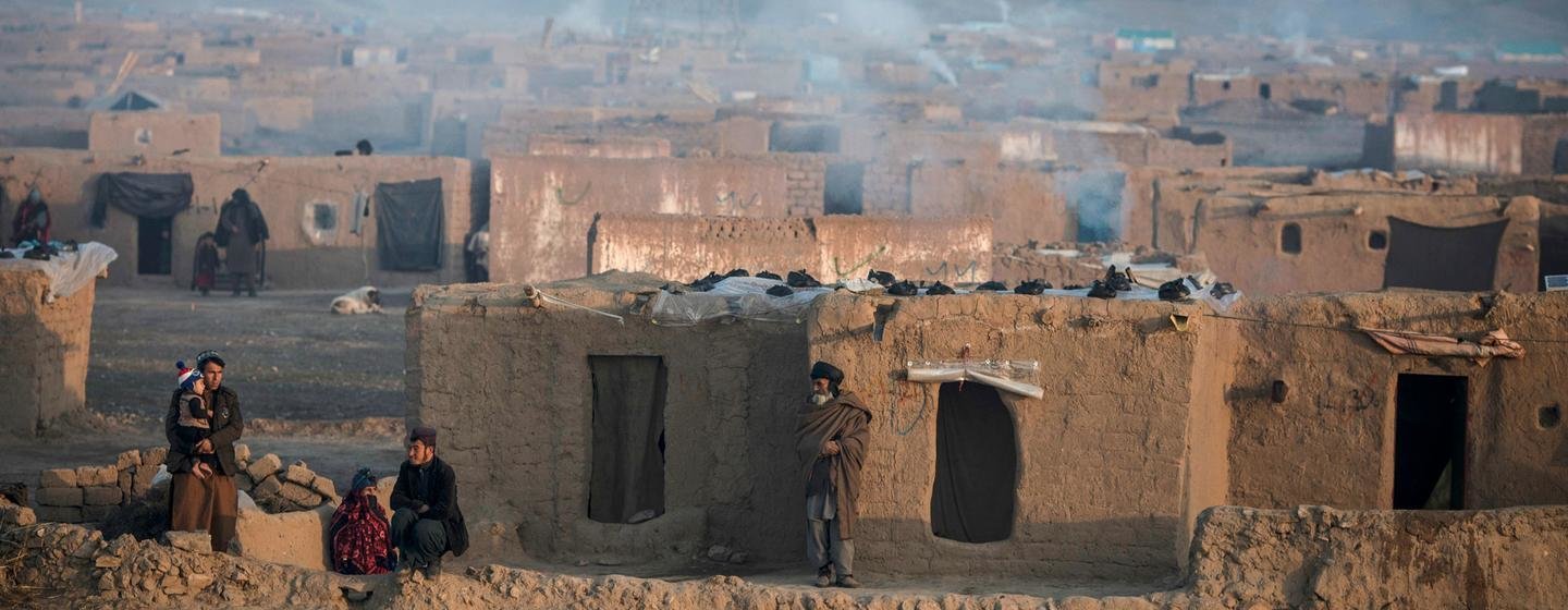 De la fumée s'échappe des cheminées des maisons d'un camp de personnes déplacées pendant un hiver rigoureux en Afghanistan.