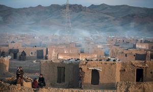 De la fumée s'échappe des cheminées des maisons d'un camp de personnes déplacées pendant un hiver rigoureux en Afghanistan.